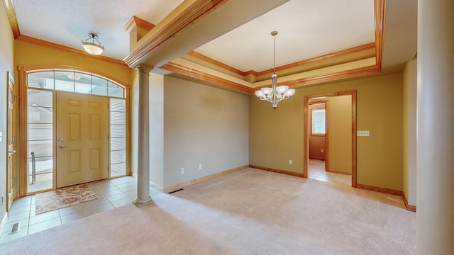 entrance foyer with an inviting chandelier, ornamental molding, decorative columns, baseboards, and a raised ceiling