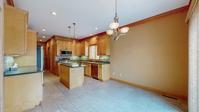 kitchen with a kitchen island, appliances with stainless steel finishes, dark countertops, a sink, and ornamental molding