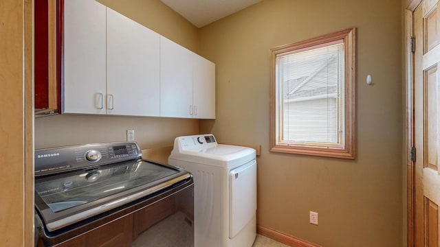 washroom featuring independent washer and dryer, baseboards, and cabinet space