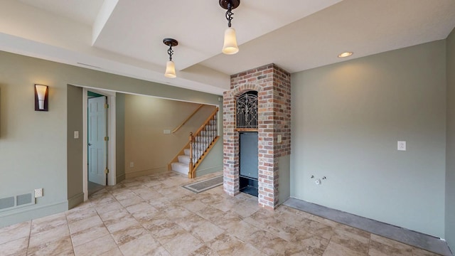 unfurnished living room with stairs, baseboards, visible vents, and a fireplace
