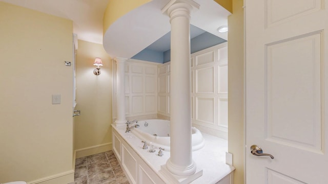 full bathroom with a whirlpool tub, decorative columns, and baseboards