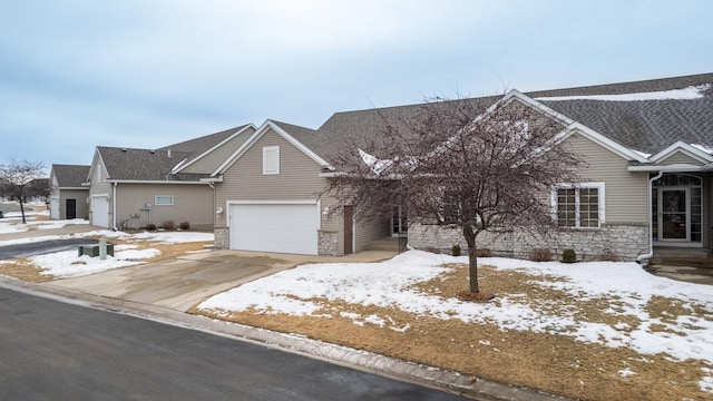 view of front of home featuring a garage, concrete driveway, and stone siding