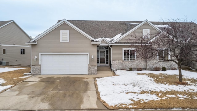view of front facade featuring central AC, driveway, stone siding, and a garage