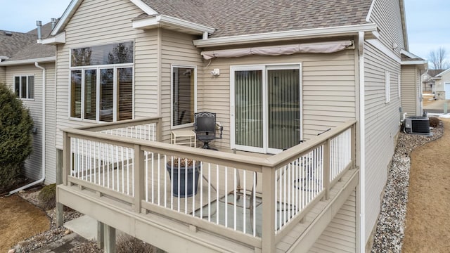 back of house featuring roof with shingles, central AC unit, and a deck