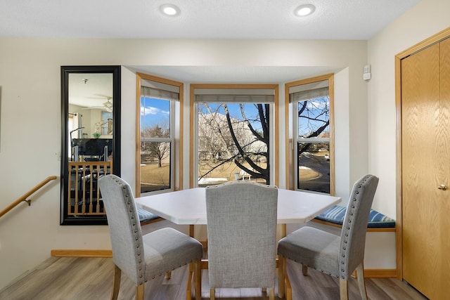 dining area featuring light wood-type flooring and baseboards