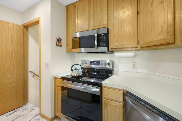 kitchen with marble finish floor, stainless steel appliances, light countertops, and baseboards