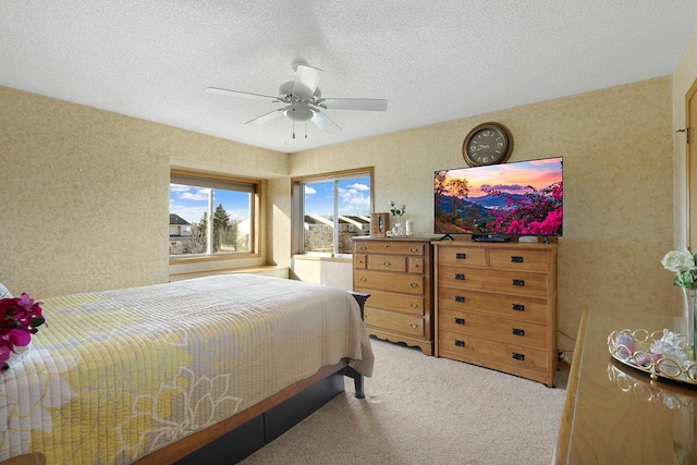 carpeted bedroom featuring a ceiling fan and a textured ceiling