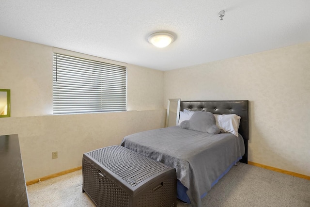 bedroom with carpet floors, baseboards, and a textured ceiling