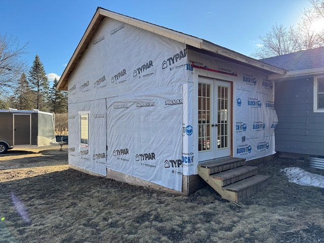 view of side of property featuring entry steps and french doors