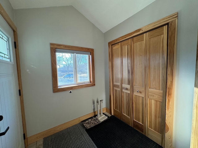 interior space featuring vaulted ceiling and baseboards