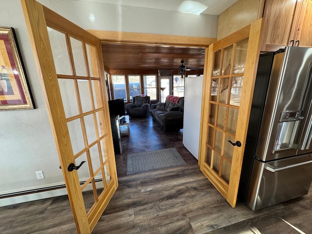 corridor with dark wood-style floors, a textured wall, french doors, and baseboard heating