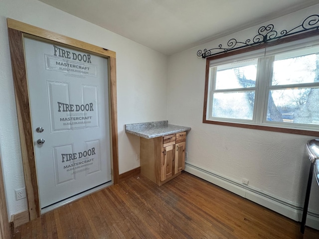 washroom featuring dark wood-style flooring, baseboard heating, and baseboards