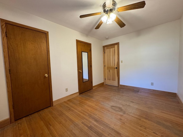 unfurnished bedroom featuring light wood finished floors, a ceiling fan, and baseboards