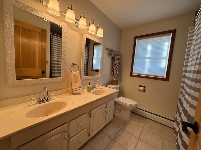 bathroom with toilet, a sink, baseboard heating, and double vanity