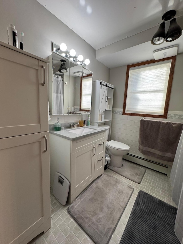 full bath with a wainscoted wall, tile walls, toilet, a baseboard heating unit, and vanity