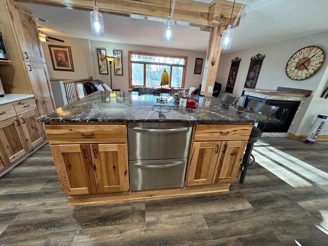 1903 Lenore Ln, Red Wing, MN 55066 - kitchen with dark wood-style floors, a glass covered fireplace, pendant lighting, and dark stone countertops