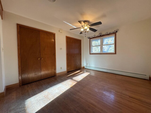1903 Lenore Ln, Red Wing, MN 55066 - unfurnished bedroom with a baseboard heating unit, two closets, wood finished floors, and baseboards