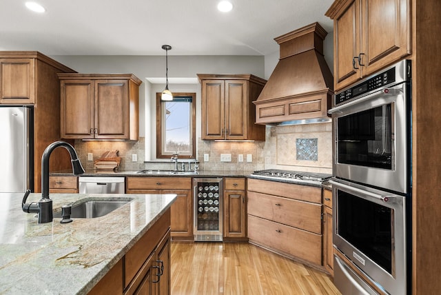 kitchen featuring custom range hood, wine cooler, stainless steel appliances, a sink, and a warming drawer