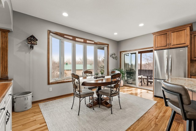 dining area with light wood-style flooring, baseboards, and recessed lighting