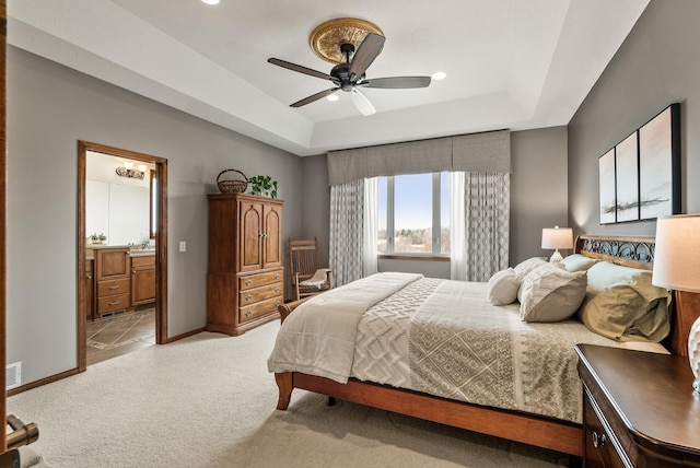 bedroom with baseboards, a raised ceiling, visible vents, and light colored carpet