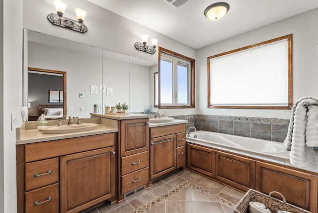 ensuite bathroom with a bath, a sink, ensuite bathroom, and double vanity