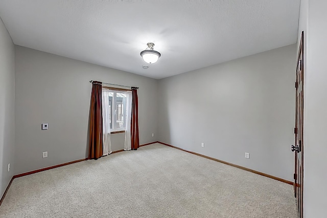 empty room with light carpet and baseboards