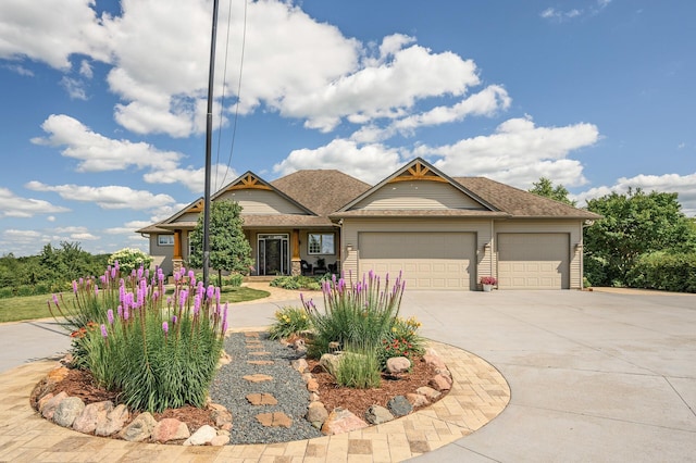 craftsman-style house featuring roof with shingles, driveway, and an attached garage