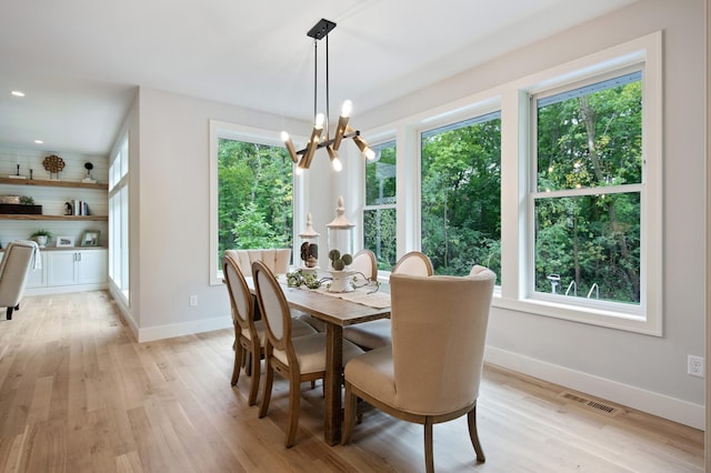 dining room featuring a healthy amount of sunlight, light wood finished floors, baseboards, and visible vents