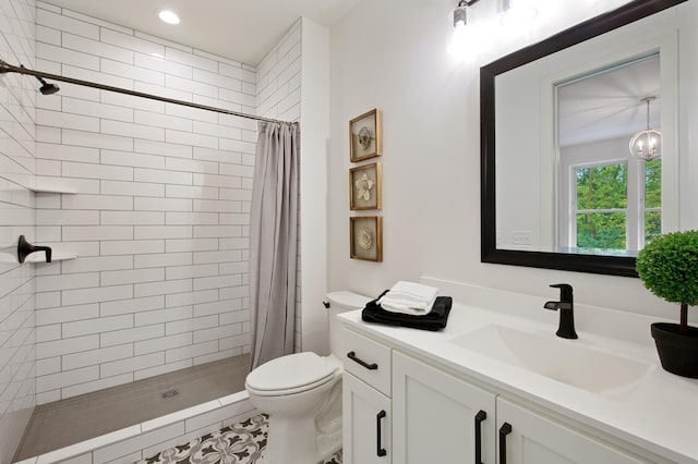 bathroom featuring toilet, a tile shower, and vanity