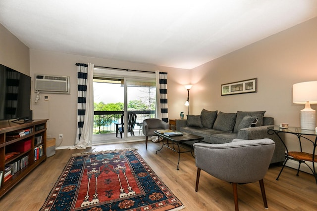 living room with a wall mounted air conditioner and wood finished floors