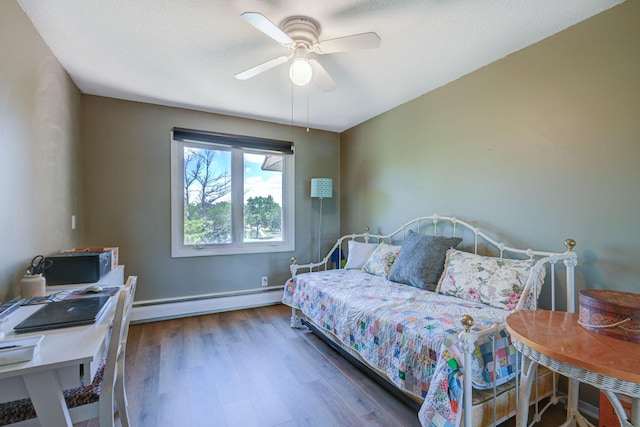 bedroom featuring a baseboard radiator, baseboards, ceiling fan, and wood finished floors