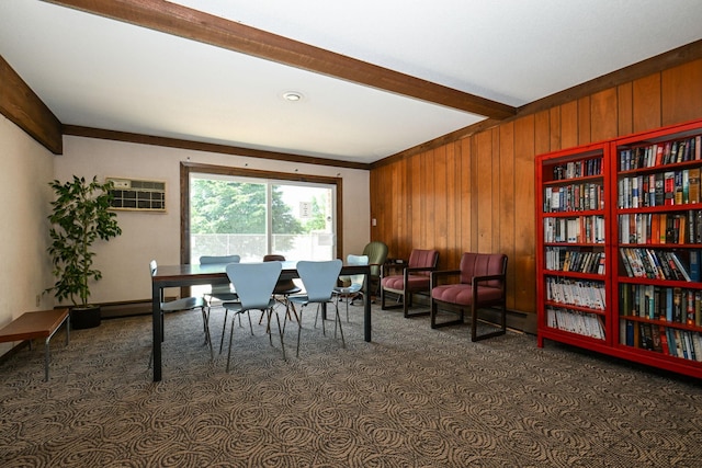 sitting room featuring wood walls, carpet, and beam ceiling