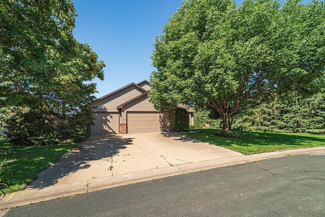 view of front of house with an attached garage, driveway, a front yard, and brick siding