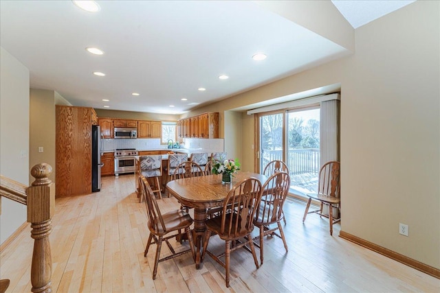 dining space featuring light wood-style floors, baseboards, and recessed lighting