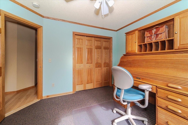 carpeted office space featuring built in study area, crown molding, a textured ceiling, and baseboards