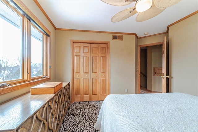 bedroom featuring ornamental molding, a closet, visible vents, and ceiling fan