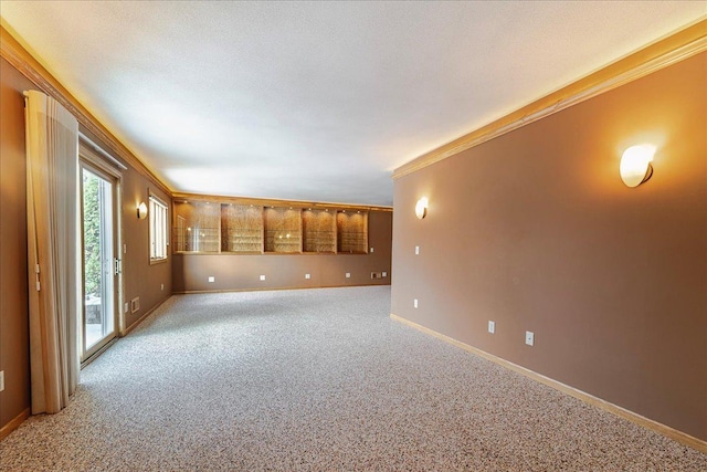 spare room with baseboards, crown molding, a textured ceiling, and light colored carpet