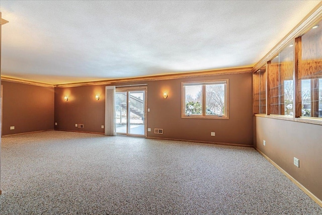 spare room with visible vents, a textured ceiling, and baseboards