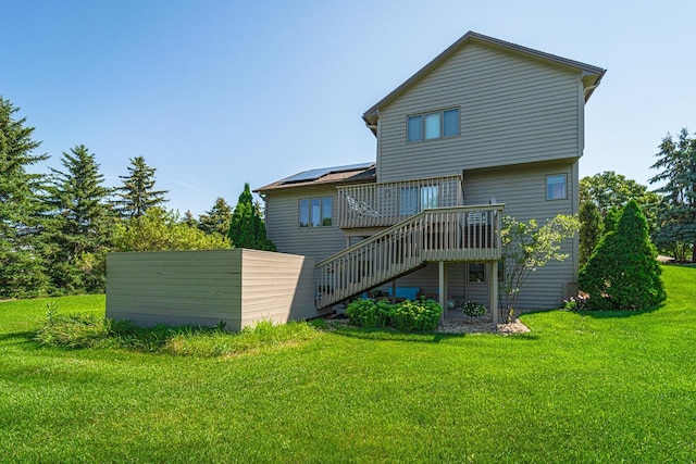 rear view of property featuring a deck, a yard, and stairway