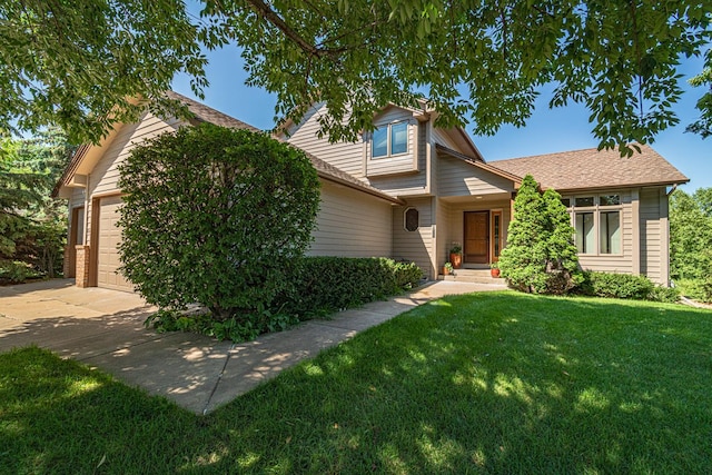 view of front of home featuring a garage, driveway, and a front yard