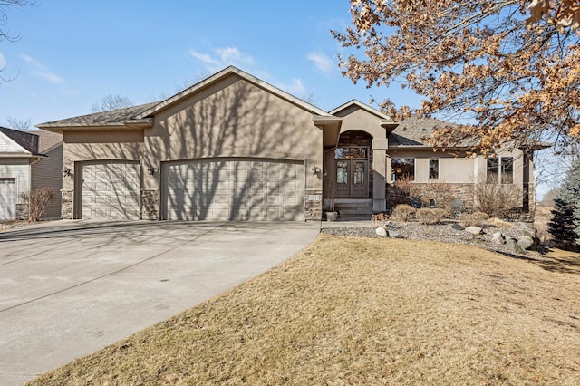 ranch-style house with stone siding, an attached garage, driveway, and stucco siding