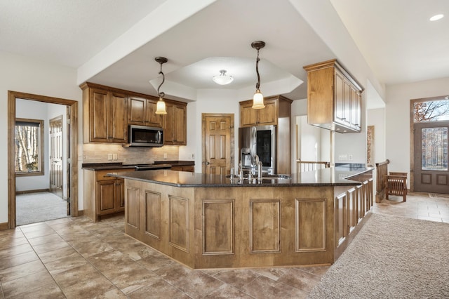 kitchen with decorative backsplash, brown cabinets, stainless steel appliances, pendant lighting, and a sink