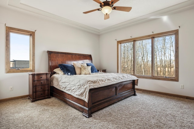 carpeted bedroom featuring ceiling fan, multiple windows, and baseboards