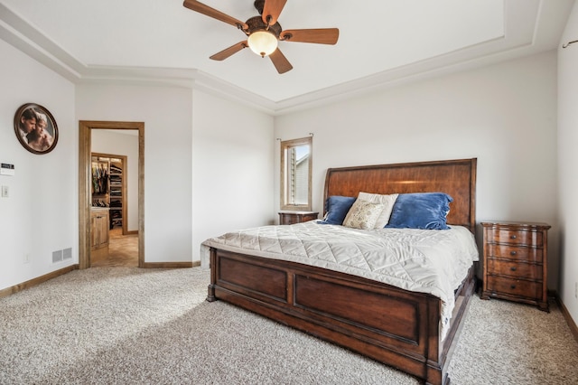 bedroom with ceiling fan, carpet flooring, visible vents, baseboards, and a raised ceiling