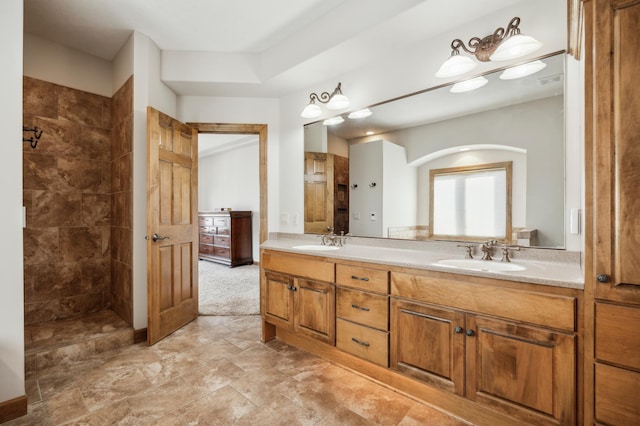 bathroom with double vanity, a walk in shower, and a sink