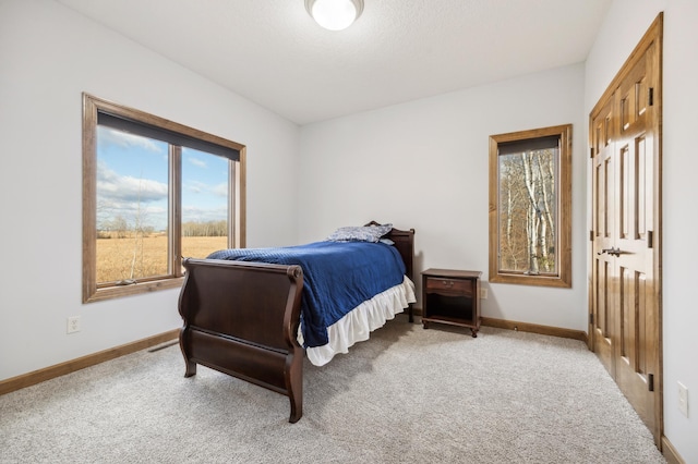 carpeted bedroom featuring baseboards