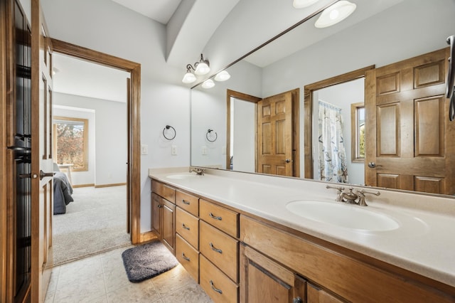 full bath featuring tile patterned floors, a sink, baseboards, and double vanity