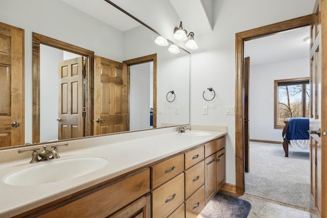 ensuite bathroom featuring double vanity, ensuite bath, a sink, and baseboards