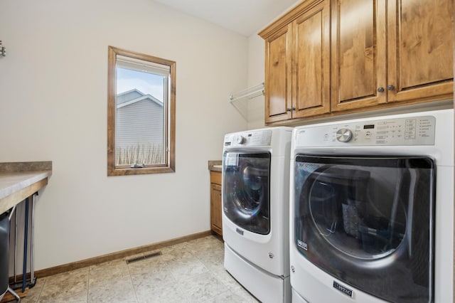 laundry room with light tile patterned flooring, visible vents, baseboards, washer and dryer, and cabinet space