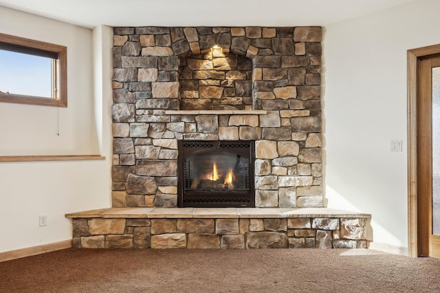 interior details with carpet floors and a stone fireplace